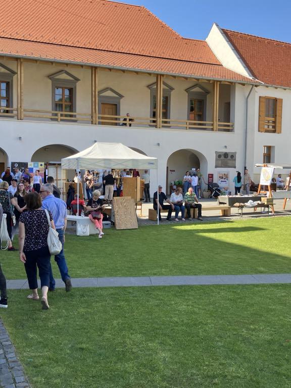 Urban Tokaj - Borša kaštiel, ľudia vonku ochutnávajú víno