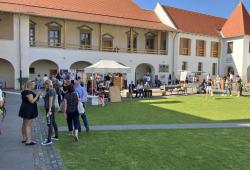 Urban Tokaj - Borša kaštiel, ľudia vonku ochutnávajú víno